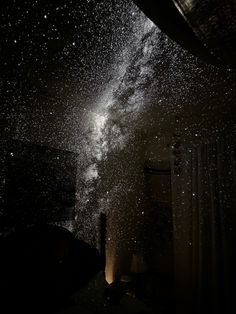 the night sky is filled with stars and lightening up from inside a dark room