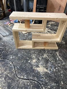 a wooden shelf sitting on top of a dirty floor