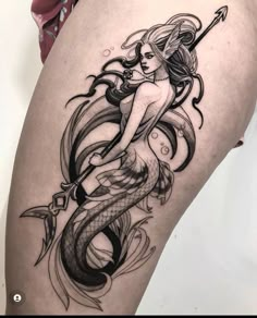 a woman with a mermaid tattoo on her thigh is holding a scallop in one hand and an arrow in the other