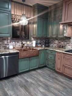 a kitchen with wooden floors and green cabinets, an oven, dishwasher and sink