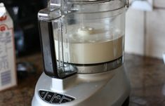 a silver blender sitting on top of a counter next to a carton of milk