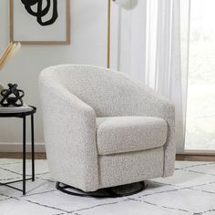 a white chair sitting on top of a rug in a living room