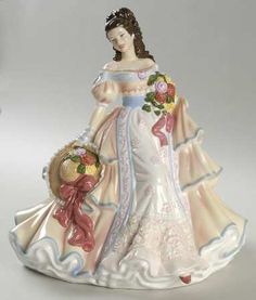 a porcelain figurine of a woman in a white dress with flowers on it