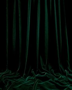 an image of a dark green curtain with the light shining on it's side