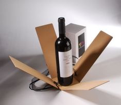 a bottle of wine sitting inside of a cardboard box next to a package with a corkscrew on it