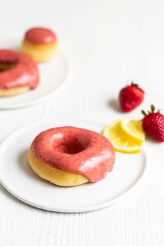 two donuts with pink glaze and lemon slices