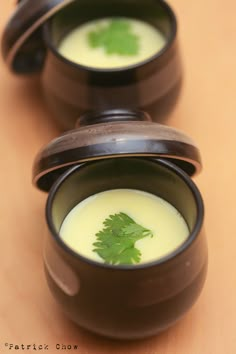 three small bowls filled with soup and garnished with cilantro on top