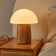 a wooden table lamp sitting on top of a night stand