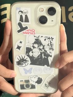 someone holding up their phone case with some stickers on it