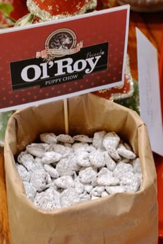 a box filled with cookies sitting on top of a table next to a sign that says o'roy puppy chow