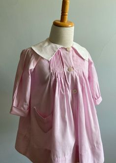 "I have had this pretty smock dress for some time now. It was purchased in Paris and needed extensive work at neckline/collar. The entire neckline was covered in vintage seam binding and an entirely new collar was made, based on the original design. It dates from the 1930's and is a gorgeous piece.                    Made of a finely woven rose pink cotton, the front bodice features ten pleats on either side of center front.  These are secured with a delicate pink and white hand embroidered band Linen Pinafore Dress, Seersucker Jacket, Linen Pinafore, 1960 Dress, Girls Smocked Dresses, Vintage Girls Dresses, Girls Smock, Seam Binding, Vintage Dresses 1960s