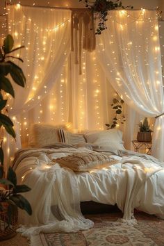 a bed with white sheets and lights hanging from the headboard in front of it