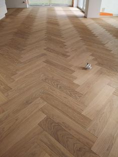 a pair of white shoes sitting on top of a wooden floor next to a doorway