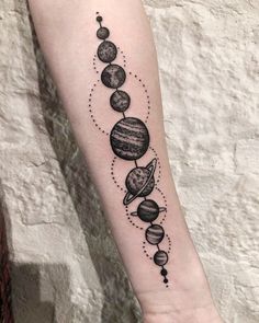 an arm tattoo with planets on it