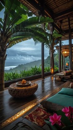 an outdoor living area with couches, tables and plants on the deck overlooking the ocean