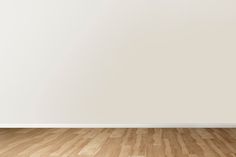 an empty room with white walls and wooden floors