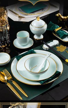 the table is set with green and gold plates, silverware, and napkins