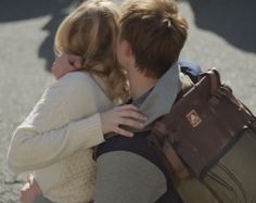 two people hugging each other on the street