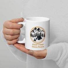 a person holding a coffee mug with the words find your own peace