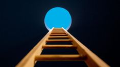 a wooden ladder leading up to a bright blue circle