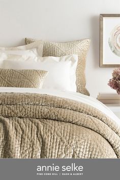 an image of a bed with white sheets and pillows