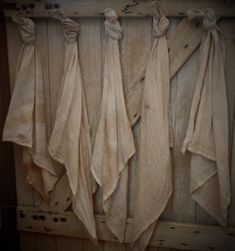 several pieces of cloth hanging on a wooden wall