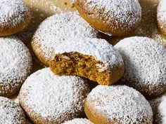 a pile of powdered sugar covered doughnuts