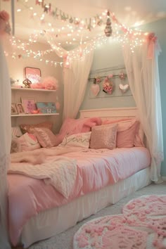 a bedroom with pink and white decor on the walls, lights strung over the bed