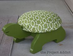 a green and white turtle ottoman sitting on the ground