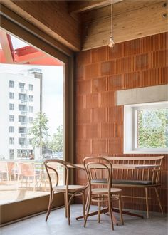 two wooden chairs sitting next to each other in front of a window with large windows