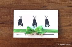 an easter card with three little bunnies on it and a green ribbon tied around them