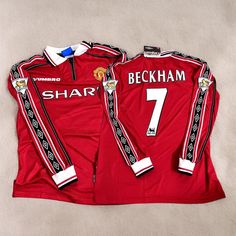 two manchester united soccer shirts, one red and one white with the number seven on it