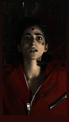 a woman in a red hoodie with her eyes open and blood smeared all over her face