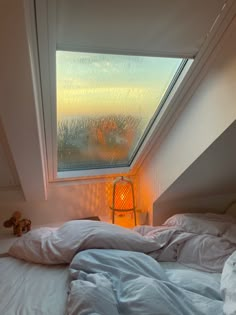 a bed sitting under a window next to a yellow light lamp on top of it