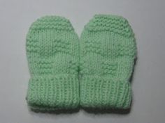 a pair of green knitted mittens sitting on top of a white countertop