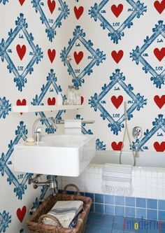 a bathroom with hearts painted on the wall next to a white sink and tiled floor