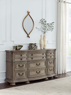 a dresser with two vases on top of it