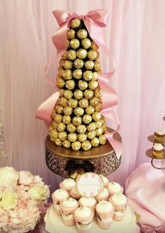 a table topped with a cake covered in lots of chocolates and cupcakes