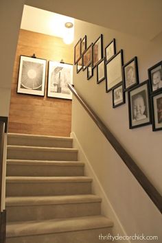 stairs with pictures on the wall and framed photographs above them in front of a stairway