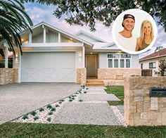 a woman standing in front of a house next to a mailbox and palm tree