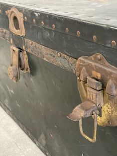 an old black trunk with brass handles and rivets on the top, is shown