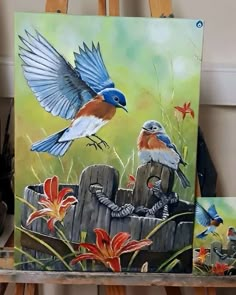 two paintings of birds sitting on top of a wooden fence