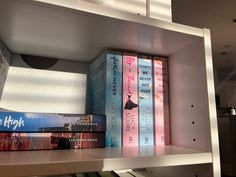 several books are sitting on a shelf in a room