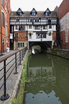 an old building next to a canal with water running under it