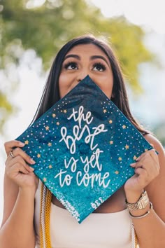 a woman holding up a graduation cap with the words best to get to college written on it