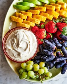 an assortment of fruits and dips on a plate