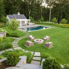 a backyard with a fire pit surrounded by lawn furniture