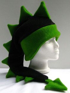 a green and black hat on top of a mannequin's head