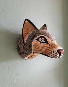 a wood carving of a wolf's head on a wall