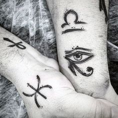 two people with tattoos on their hands holding each other's hand and one has an eye